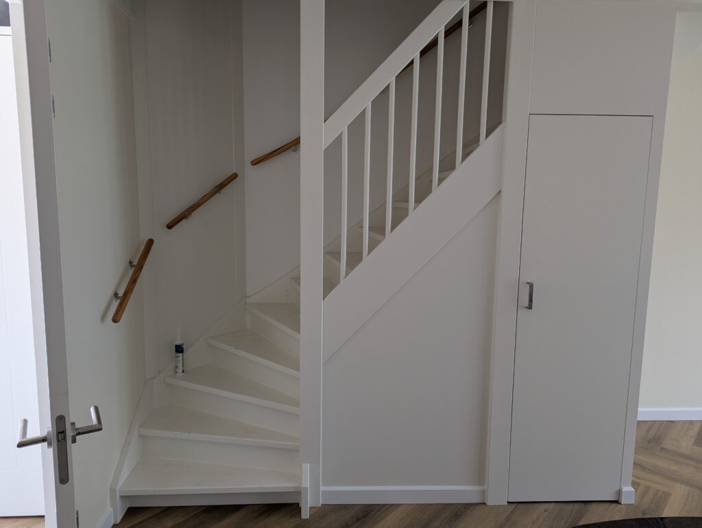Maatwerk trapkast die een complete kast vormt, ontworpen om een ongebruikte ruimte functioneel te maken, met slimme indeling 